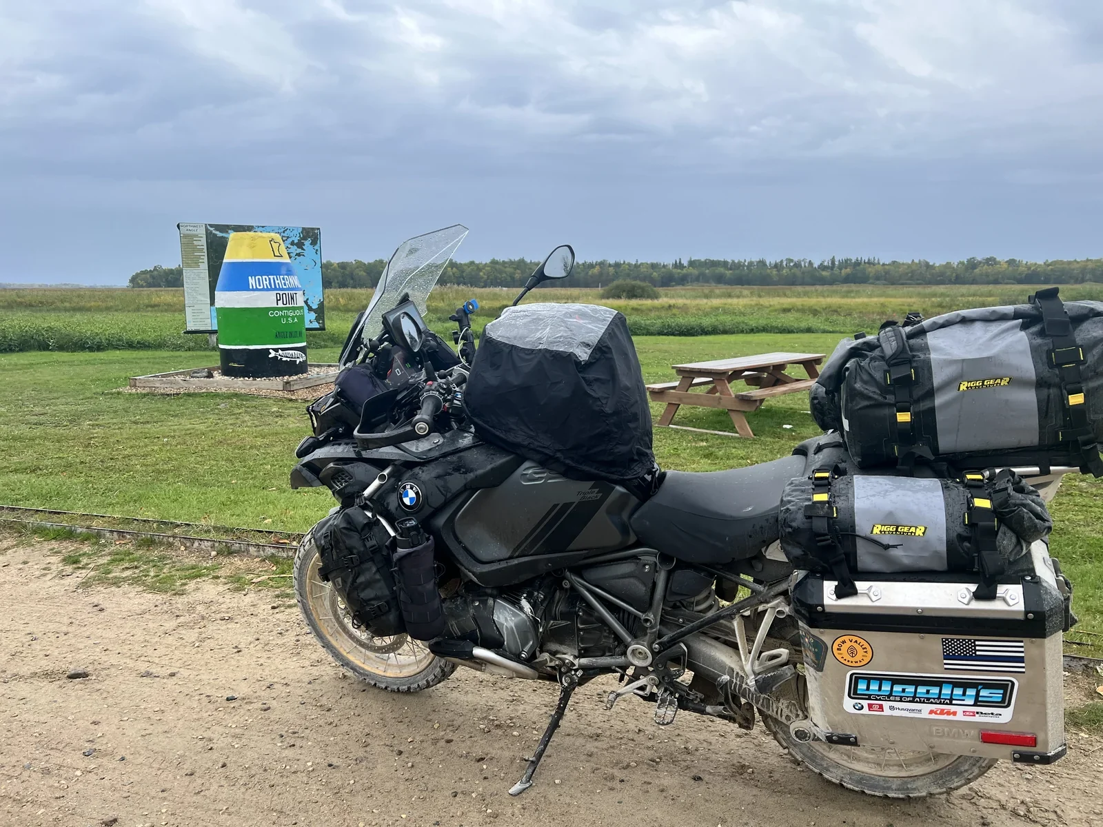 Fully loaded BMW adventure motorcycle beside the Northernmost Point marker during Paul Larson’s multi-month journey.