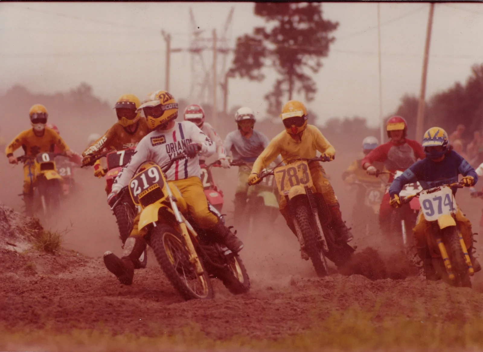 Paul Larson racing motocross on motorcycle number 219 among a field of riders.